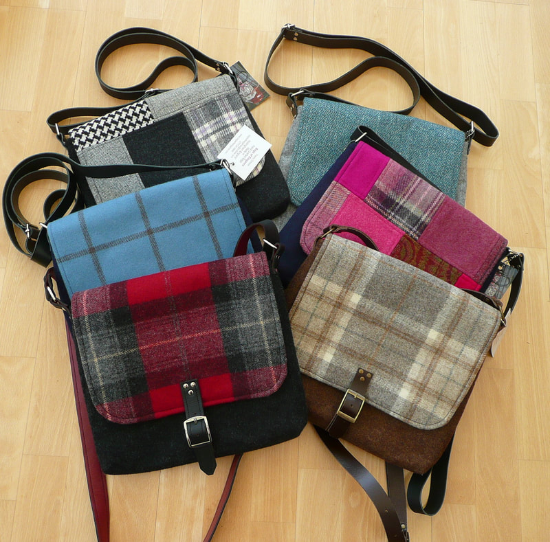 a selection of tweed crossbody bags laying in a pile on a wooden floor
